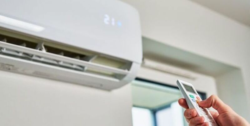 A man operates a split system air conditioner
